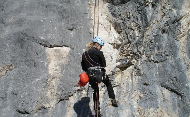 Woman abseiling down a cliff face