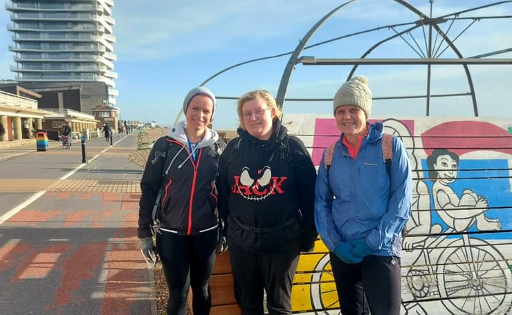 Three women on Worthing seafront pause during their run
