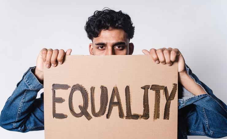 Man holds up card with word Equality