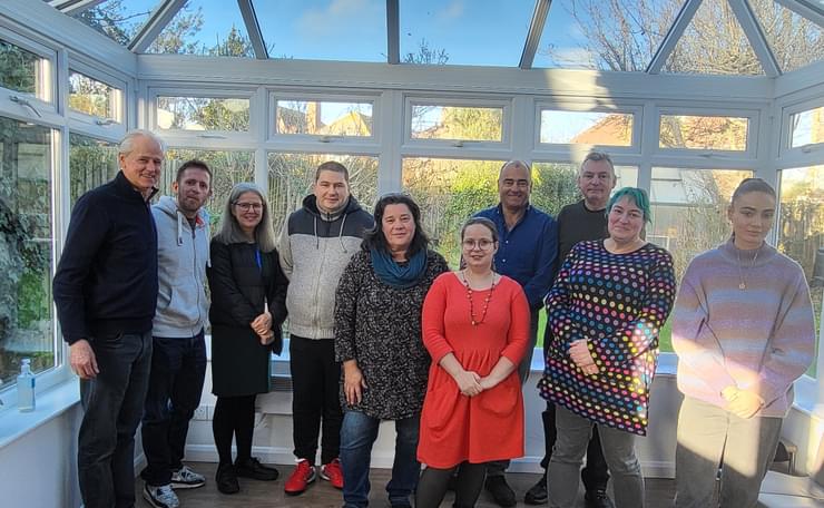 Ten people in the conservatory at West Sussex Mind's Littlehampton support hub: our group of peer volunteer trainees with East Head Impact representatives who funded the training