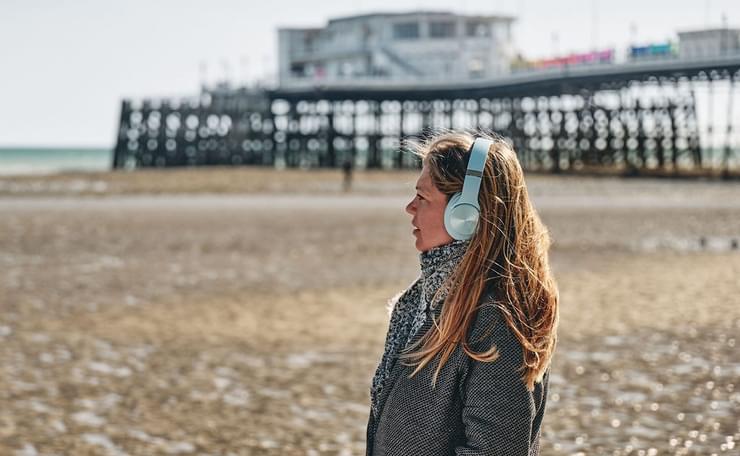 keira with headphones, pier in background