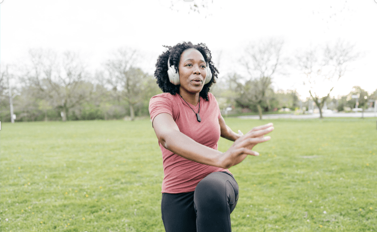 Woman with headphones taking exercise in a park