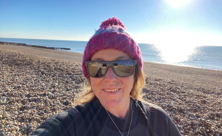 Photo of sea swimmer wearing a pink hat at the beach with sunny background